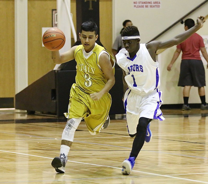 Image: JV Gladiator Jorge Galvan(3) pushes the ball up the floor as a Gateway Gator defender chomps at his heels.