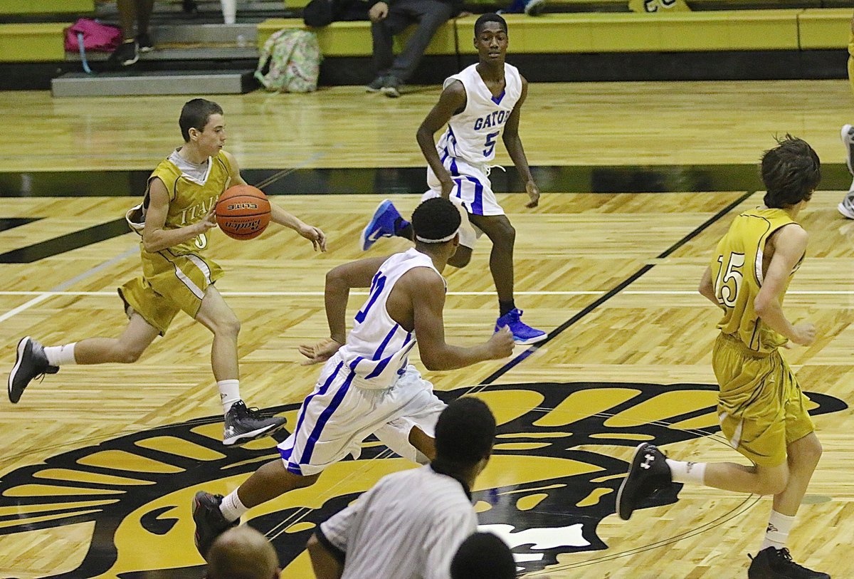 Image: JV Gladiator Dylan McCasland(3) hurries the ball across mid court with teammate Ty Hamilton(15) running the floor.