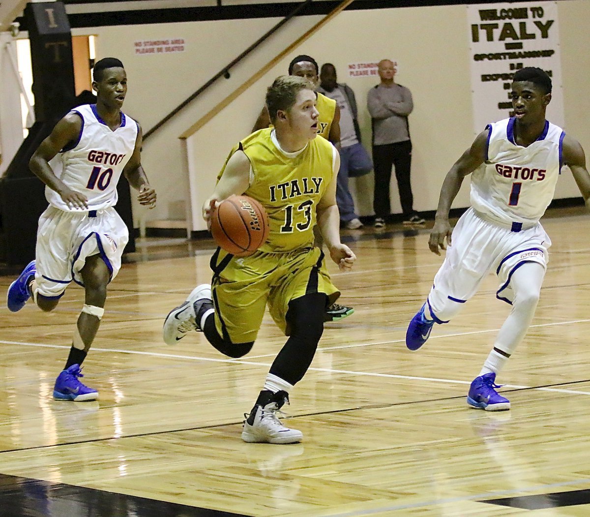 Image: Senior guard John Escmailla(13) dribbles away from Gator defenders.