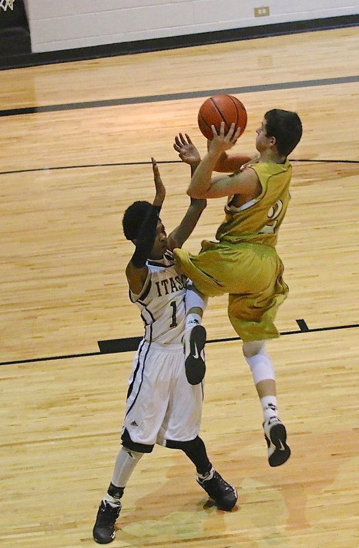 Image: Gary Escamilla(2) rises high above a JV Wampus Cat defender to attempt a layup.