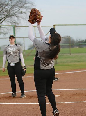 Image: First-baseman Jenna Holden(11) catches a popup with teammate Jaclynn Lewis admiring Holden’s skill.