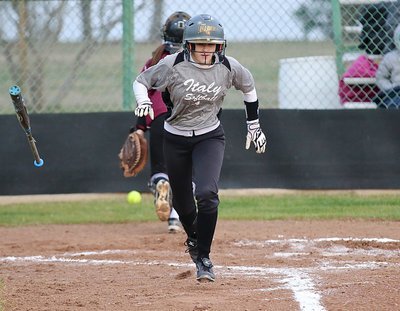 Image: Italy’s Britney Chambers(4) scrambles to safely to first-base off a miscue by Red Oak.