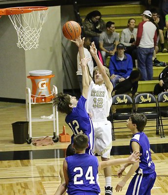 Image: JV Gladiator Garrett Janek(12) rises up and over an outstretched Polar Bear paw to get the shot off.