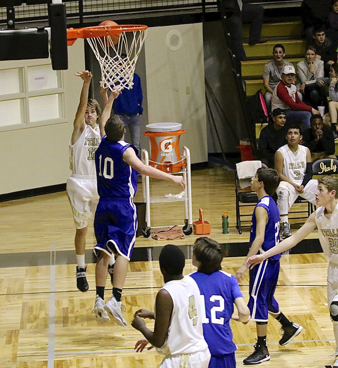 Image: Italy’s Garrett Janek(12) tries his luck from the baseline with teammates Anthony Lusk(4) and Michael Hughes(25) in position to rebound.