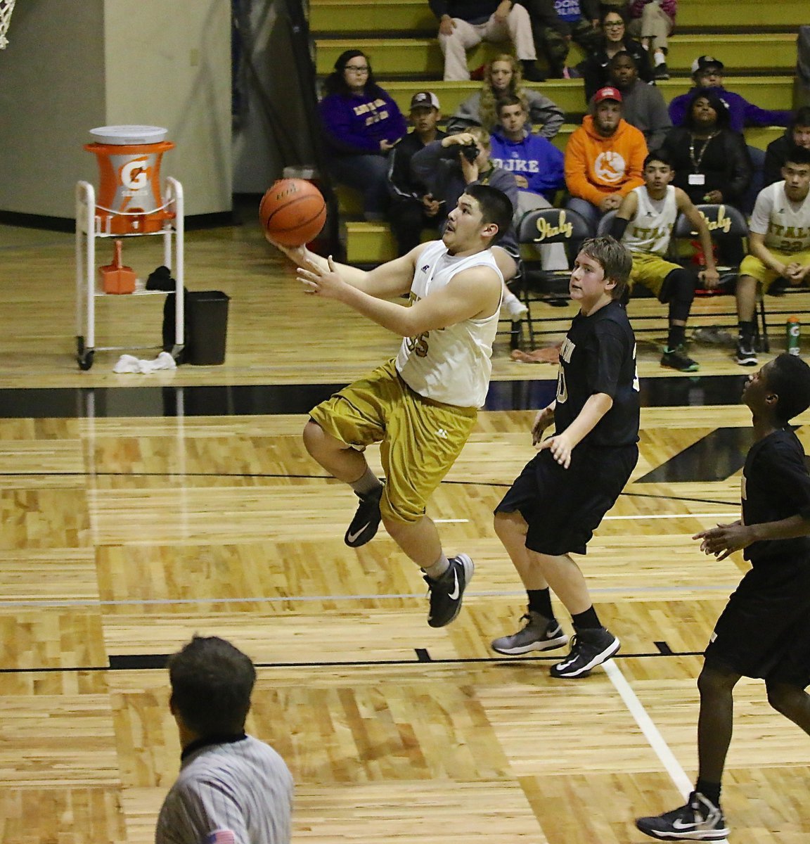 Image: Alex Garcia(35) defies gravity in an attempt to finish the fast break with a bucket.