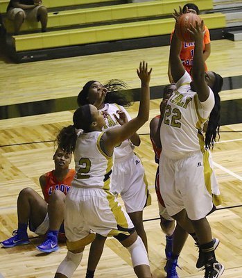 Image: Taleyia Wilson(22) secures an offensive rebound for the Lady Gladiators with teammates Emmy Cunningham(2) and Janae Robertson(5) also down low battling for rebounds.