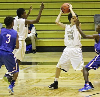 Image: JV Gladiator Ty Hamilton(15) protects the ball while his guard, Byron Lusk, Jr.(1) gets open for the pass.