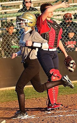 Image: Lady Gladiator Kirsten Viator(22) crosses home plate during the blast by teammate Madison Washington.