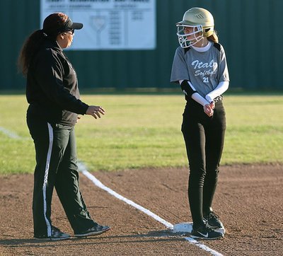 Image: Lady Gladiator head coach Tina Richards coaches up freshman Paige Cunningham at third-base.