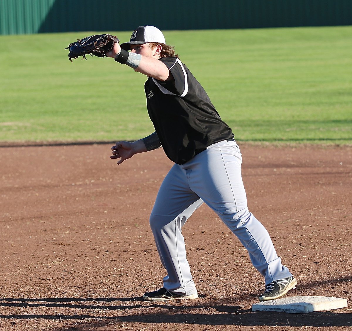 Image: Tyler Vencill secures an out while covering first-base.