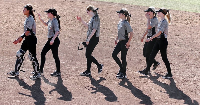 Image: The shadows of April Lusk(7), Cassidy Childers(3), Kelsey Nelson(14), Kirsten Viator(22), Bailey Eubank(1) and Paige Cunningham(21) walk out to shake hands with Palmer’s squad after the contest.