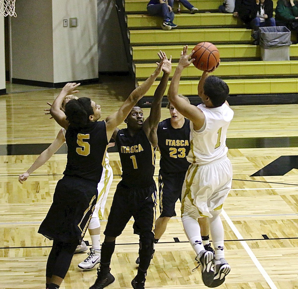 Image: Gladiator Joe Celis(1) spins and shoots over a pair of Wampus Cat defenders.