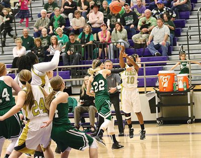 Image: With teammates Cory Chance(33) and Lillie Perry(24) jockeying for position beneath the basket, Lady Gladiator K’Breona Davis(10) shoots a three-ball from the corner.