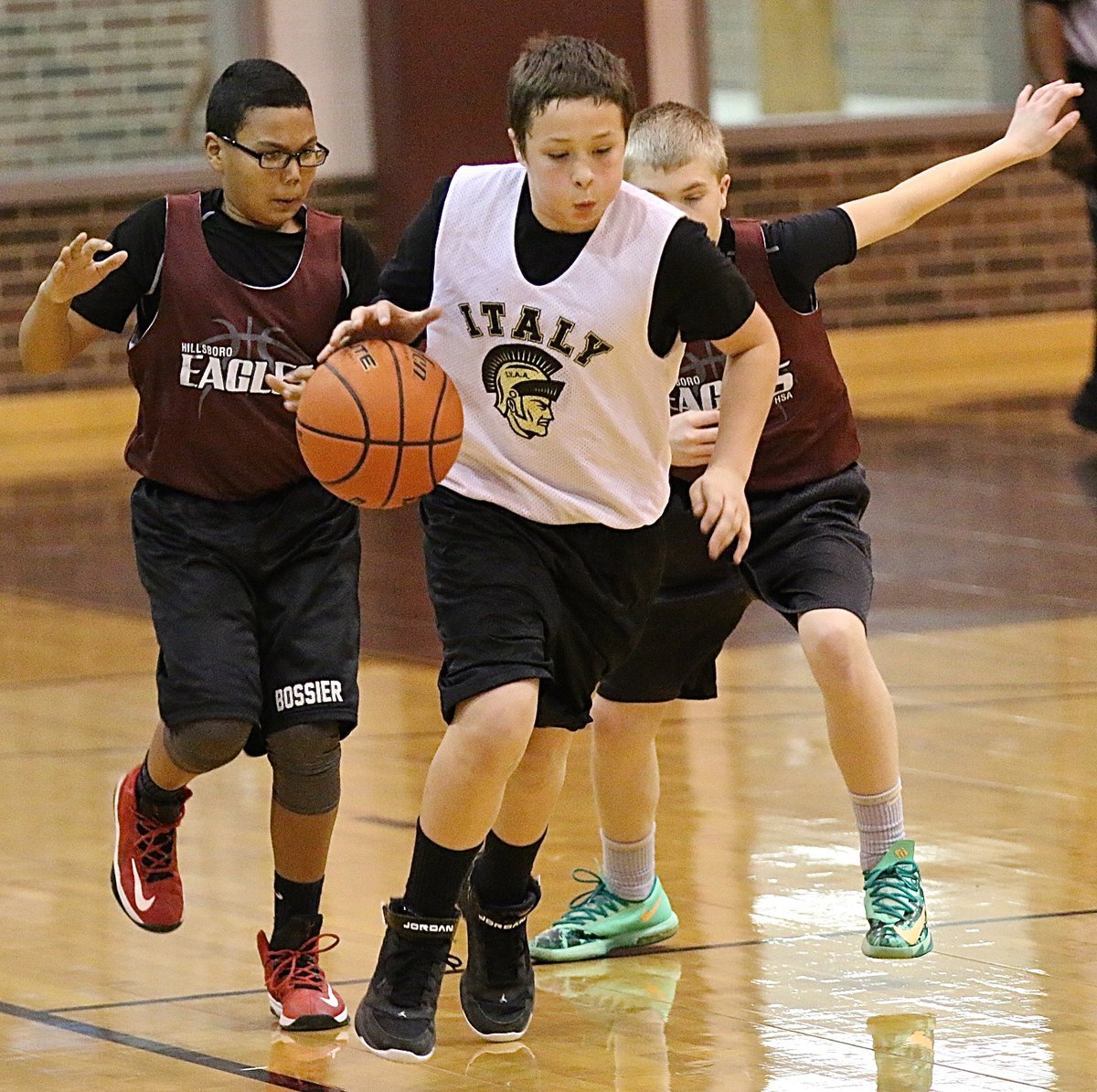 Image: Jayden Saxon(8) powers thru a pair of Hillsboro defenders while pushing the ball.