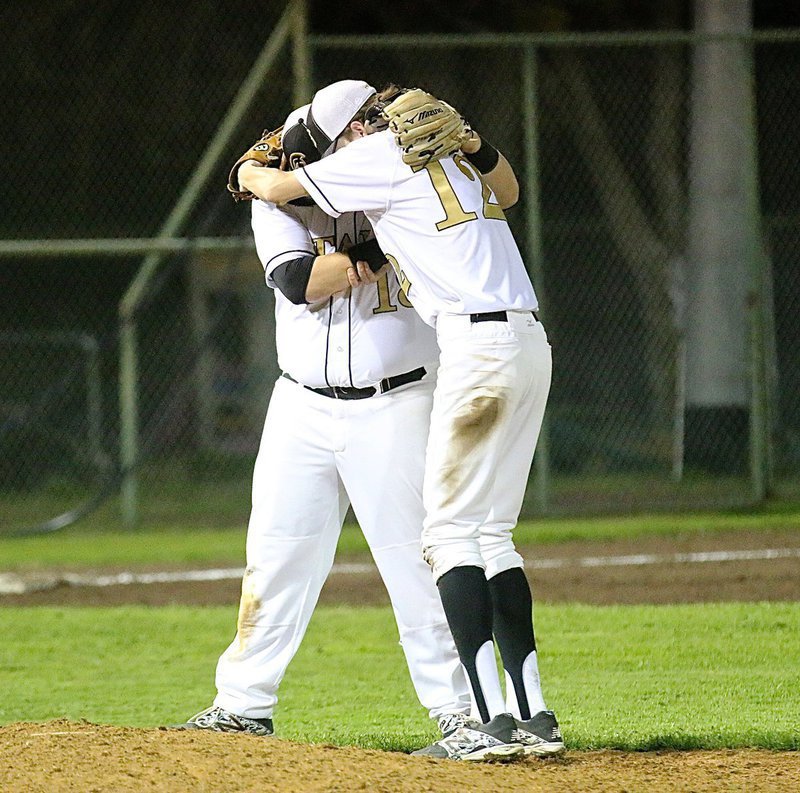Image: Third-baseman John Byers(18) and pitcher Ty Windham(12) hug for luck to start the top of the fifth-inning.