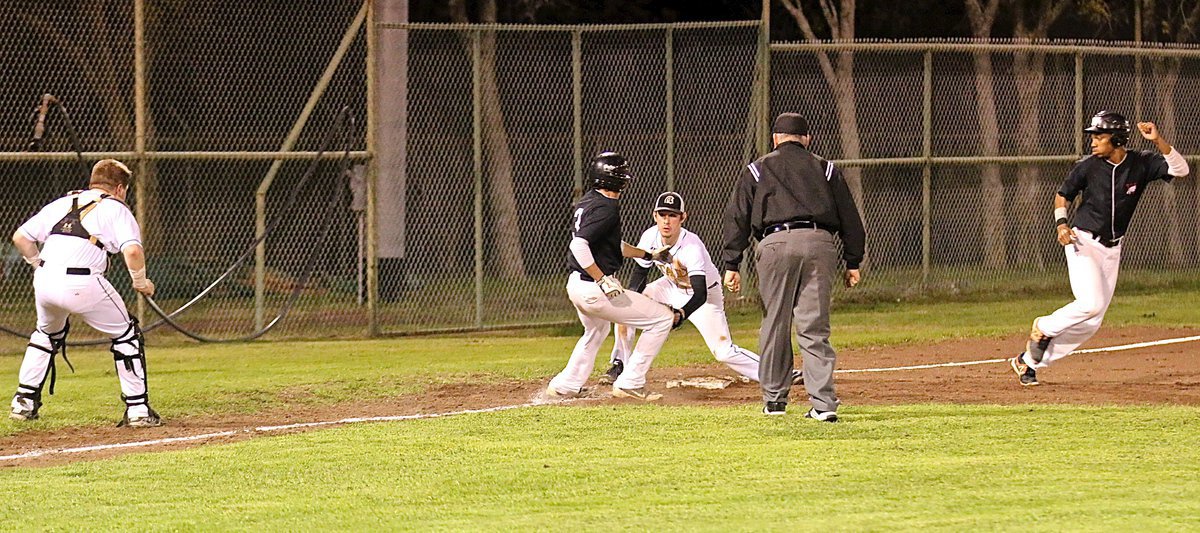 Image: Italy catcher John Escamilla(7) tosses the ball to shortstop Ryan Connor(4) who covered third-base during the run down. Connor made the catch and then made the tag for an out.