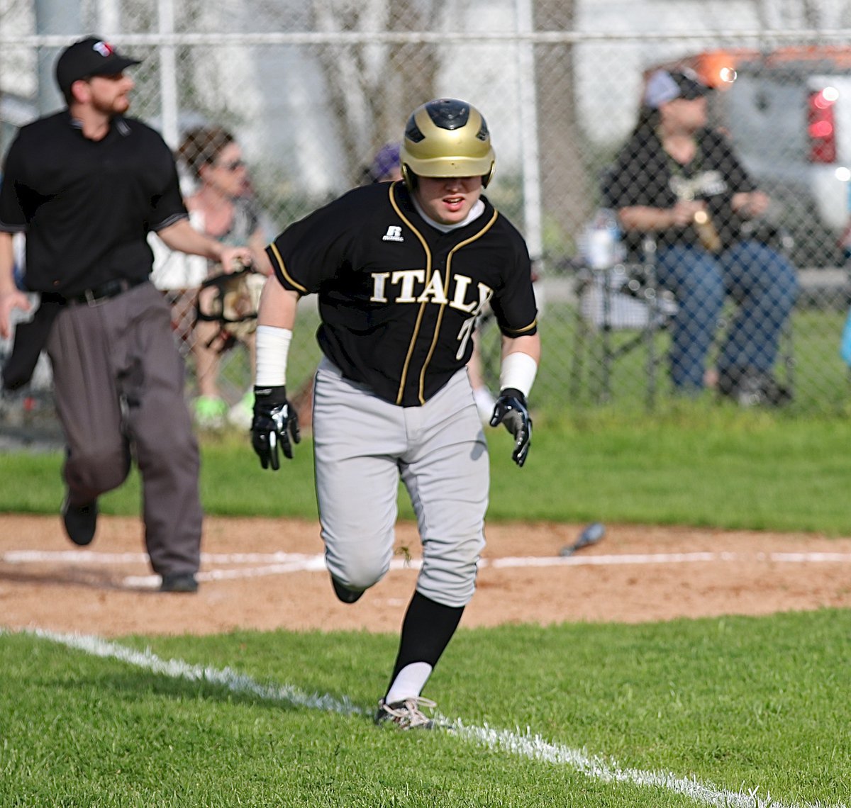 Image: Italy’s John Escamilla(7) down the first-base line after hitting the ball into play against the Polar Bear defense. Escamilla would later hit a double.