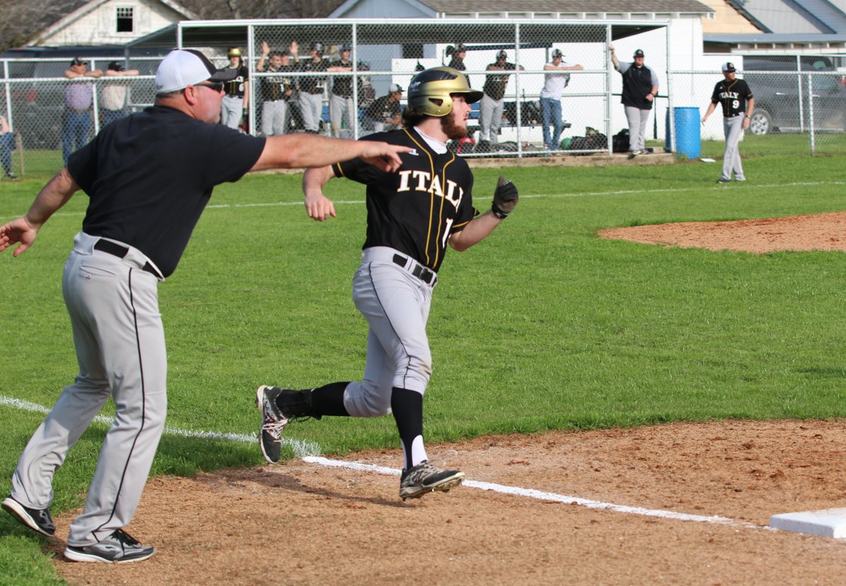 Image: First-base coach Jackie Cate instructs Kyle Fortenberry(14) to turn and look around first-base.