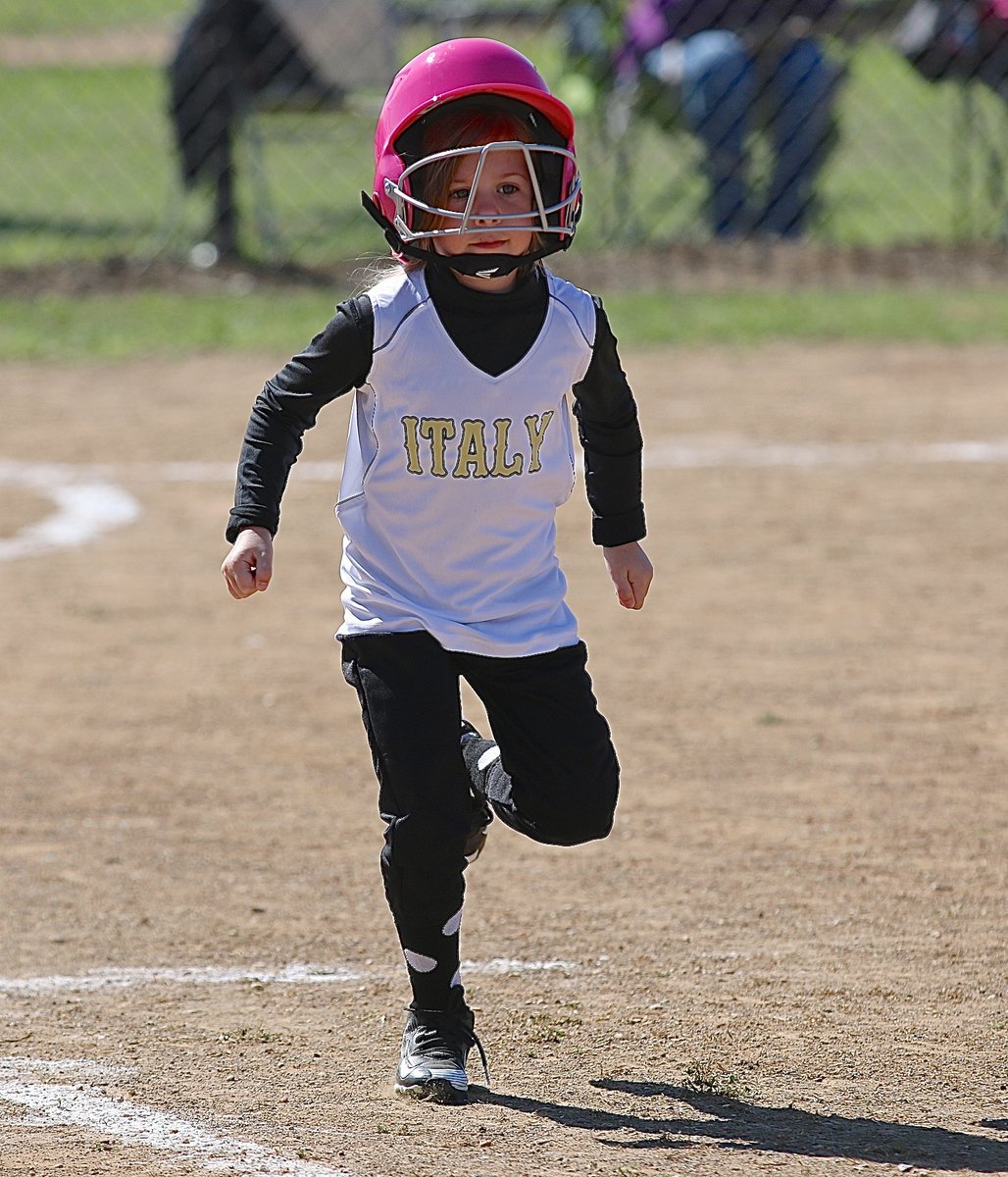 Image: Italy’s Alex Creighton hustles to first base after hitting the ball of the batting tee.