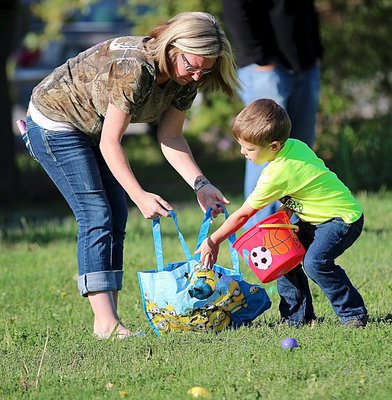 Image: Misty Gwin helps her son Hagen with his abundance of Easter eggs.