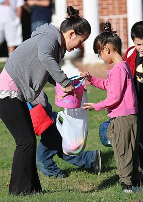 Image: Mei Lin helps daughter Annie empty her Easter bucket.