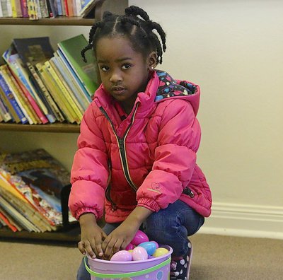 Image: Raya keeps filling her bucket full of Easter eggs during the hunt inside the library.