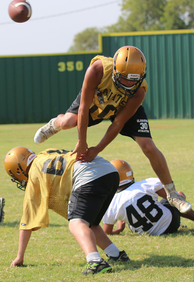 Image: Linebacker Joe Celis(50) leaps over a block by Hunter Morgan(66).