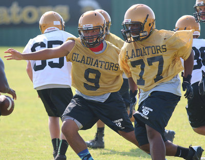 Image: Jorge Galvan(9) and Kenneth Norwood(77) swarm the backfield during team drills.