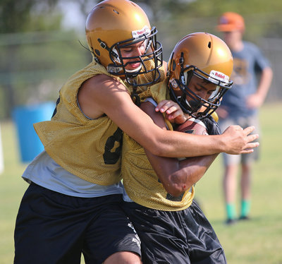 Image: Mason Womack roughs up teammate Fabian Cortez as Womack tries to to separate Cortez from the pigskin.