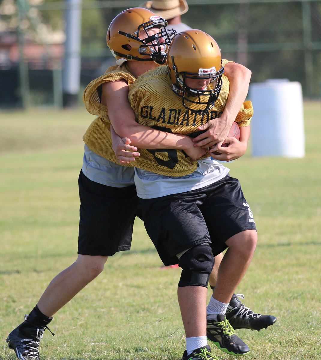 Image: Clay Riddle(60) tries to strip the ball away from teammate Hunter Morgan(66).