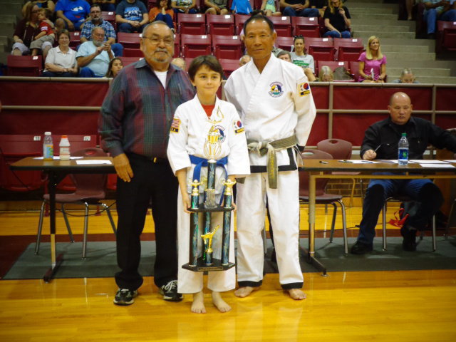 Image: Antonino Procopio, attends Italy ISD and has earned his first, 3 foot trophy after earning a 4 foot trophy in the past.
    Pictured is Master Charles Kight, chief instructor of the Hillsboro TKD school, Antonino and Grand Master Park co-founder of Unified TKD.
