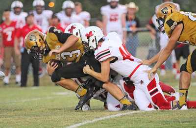 Image: Gladiator and senior tailback Hunter Merimon(3) drags Panther defenders behind him as he inches forward.
