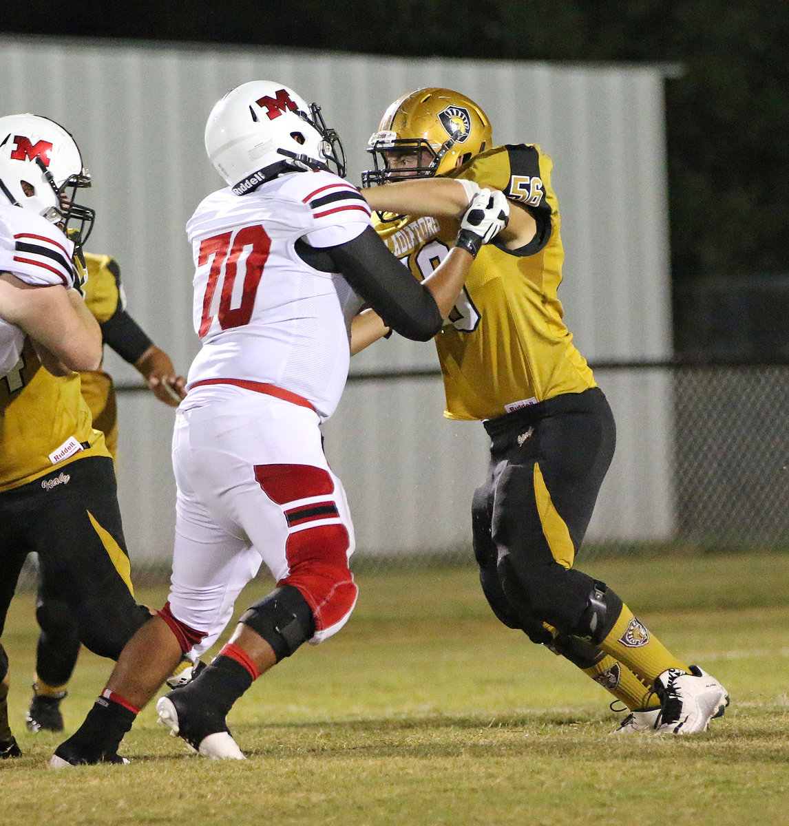 Image: Senior Gladiator lineman Austin Crawford(56) ties up a Maypearl defender as Italy punts the ball away.