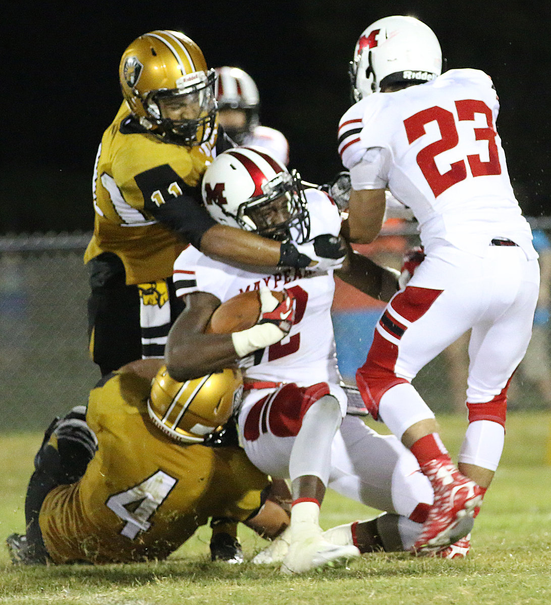 Image: Gladiators Micah Escamilla(4) gets a helping forearm from teammate Fabian Cortez(11) as the twosome drag down a Maypearl running back.