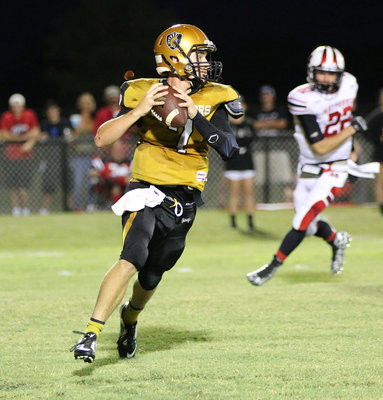 Image: Senior Gladiator quarterback Ryan Connor(7) rolls out looking for a receiver against the Panther defense.