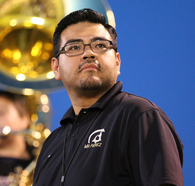 Image: Gladiator Regiment Band Director Jesus Perez takes a look at the action on the field.