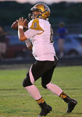 Image: Gladiator quarterback Joe Celis(8) prepares to launch the deep ball over the manes of the Lions.
