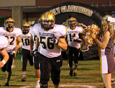 Image: Senior Austin Crawford(56) and his fellow Gladiators charge onto the field for the start of the second-half against Blooming Grove.