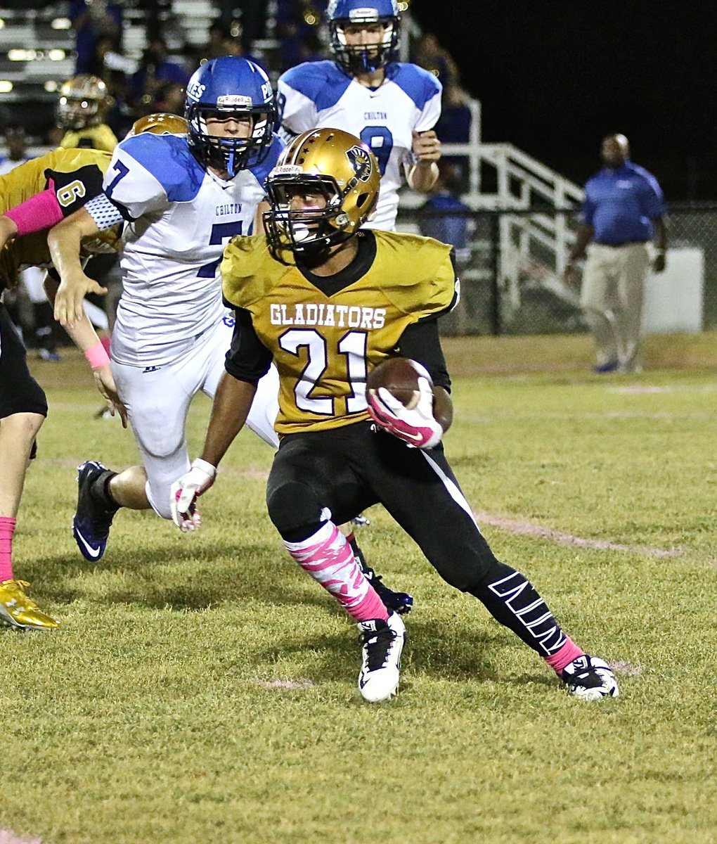 Image: Gladiator Jaray Anderson(21) turns the ball up against the Pirate defense.