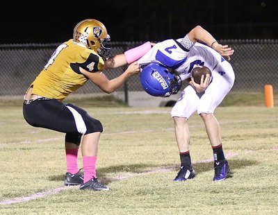 Image: Defensive end Micah Escamilla(4) brings down a Pirate runner for a loss in the Chilton backfield.