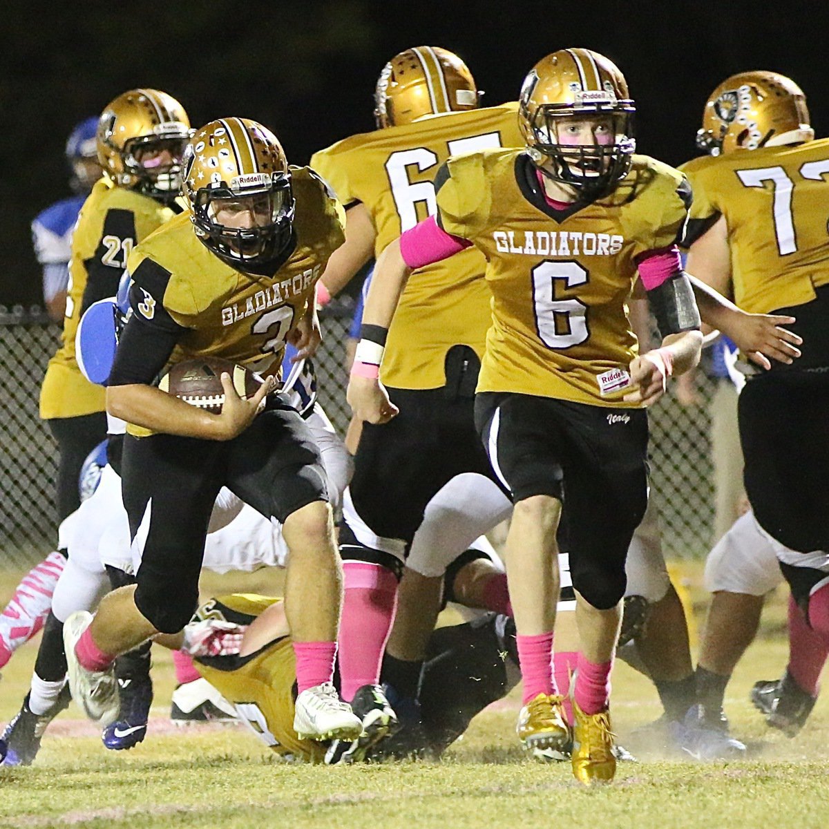 Image: Clayton Miller(6) leads the way for his brother Hunter Merimon(3) on the way to a Gladiator touchdown.