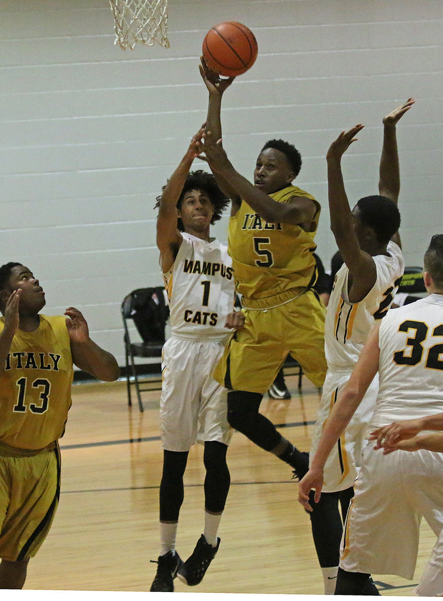 Image: Italy point guard Kevin Johnson(5)  gets to the basket for 2 of his 12-points against Itasca.