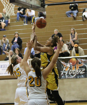 Image: Lady Gladiator Emmy Cunningham(2) draws a foul while attacking the basket from the baseline.