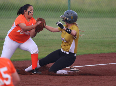 Image: Italy’s Hannah Washington slides in safely to third-base just before the tag is made.