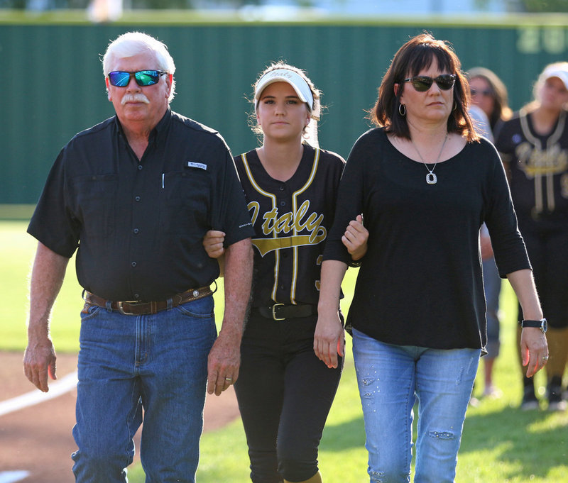 Image: Italy Lady Gladiator senior Cassidy Childers is being escorted by her parents before the game while being honored during Senior Day at Johnny Jones Field.
