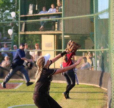 Image: Third-baseman Hannah Washington(8) goes after a foul ball near the fence.