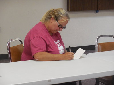 Image: Kim Varner writes a note of encouragement for a student.