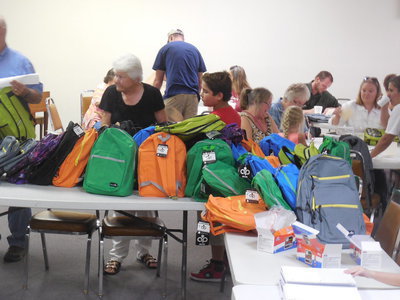 Image: LaDonna Sparks helps pack backpacks.