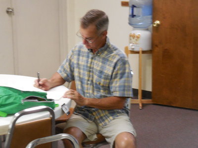 Image: Steven Varner writes a note to place in the backpack he prepared.