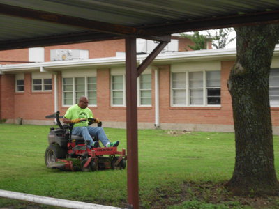Image: Larry Mayberry mows the grass in front of Stafford.